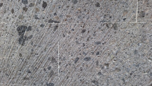 Grey Basalt Stone Texture Background with Dark Inclusions and Faint Scratches
