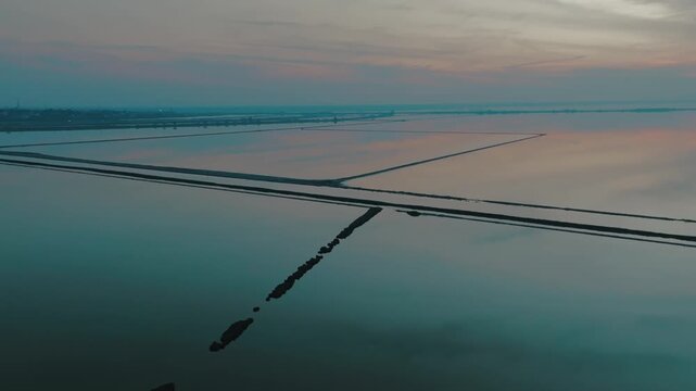 Aerial view of the tranquil Sambhar Salt Lake reflecting the pastel hues of the dawn sky, creating a mesmerizing contrast of colors, Sambhar, Rajasthan, India.