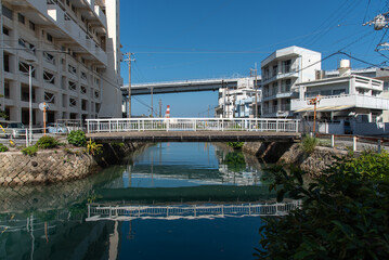沖縄の川をまたぐ手前の歩行者用の橋と海をまたぐ泊大橋