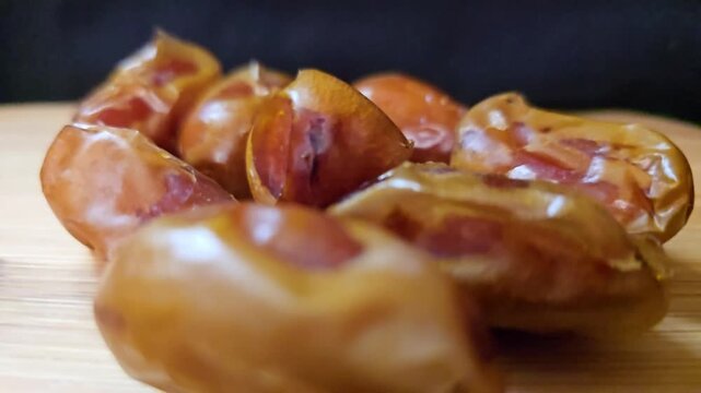 A high-quality macro video showcasing premium Saudi Khalas dates, capturing their natural sheen and rich caramel-colored skin.
