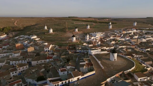 Aerial view of the iconic windmills standing tall against the landscape, contrasting with the clustered white-walled buildings, Campo de Criptana, Castile-La Mancha, Spain.
