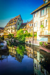 Obraz premium half timbered crooked houses of Colmar with reflections in water, Alsace, France