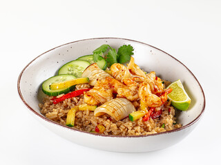 Asian fried rice with shrimp, calamari, and fresh vegetables in a bowl isolated on white.