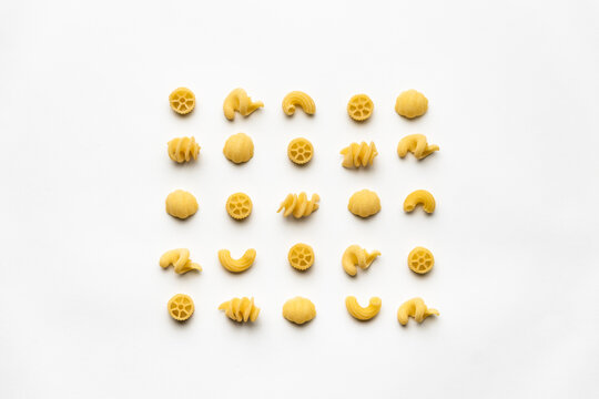 few uncooked pasta types on white background. different pasta, insalata di pasta. texture, food pattern
