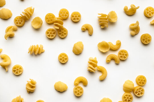 few uncooked pasta types on white background. different pasta, durum wheat semolina pasta, insalata di pasta. texture, food pattern