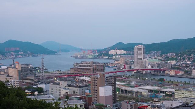 Nagasaki, Japan. Aerial timelapse made from a hill in Nagasaki, Japan, with a view over the entire center, including the bay and the hills. Cloudy and sunny morning in summer