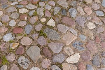 a reconstructed ancient road made of multicolored stones, cobblestones and pebbles, close up