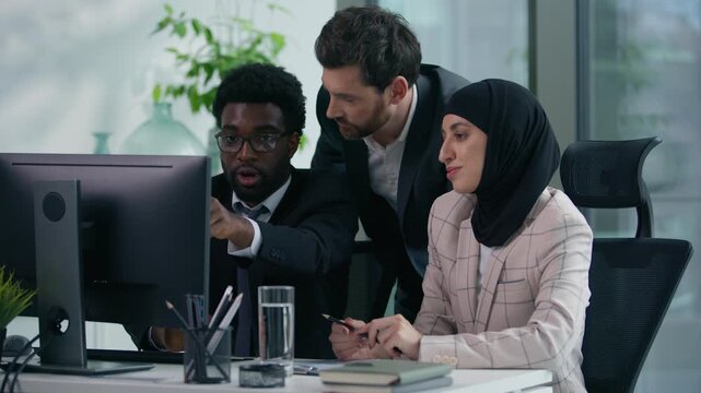 Multicultural business colleagues teamwork in office multiracial three co-workers working together diversity partners businesspeople talking pointing in computer meeting brainstorming work process