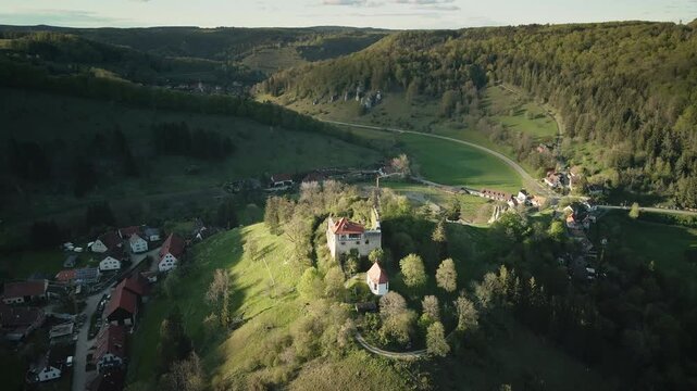 Smooth 4K UHD drone push-in flying forward toward Burgruine Niedergundelfingen on the Schlossberg (Umlaufberg of the Gro&szlig;e Lauter) near M&uuml;nsingen-Gundelfingen, with the Lautertal landscape and village