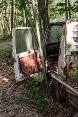 竹林に放置された錆びた軽トラックの廃車風景