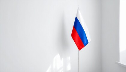 Naklejka premium Russian flag standing in corner of white room with natural light