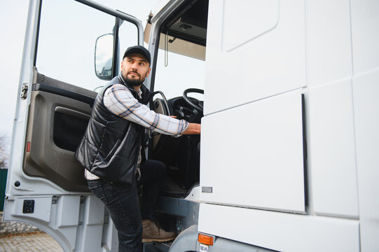 Truck driver entering cabin for road journey