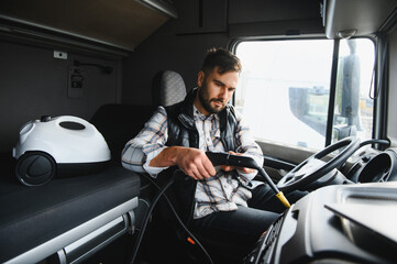 Trucker cleaning truck cab interior with steam cleaner