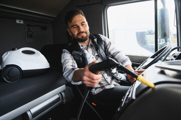 Truck driver cleaning cab interior with steam cleaner