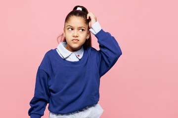 Little confused kid girl 8-9 years old wear blue shirt put hand on head scratch temple isolated on...