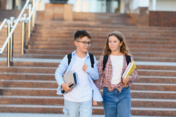 Schoolchildren walking together on school campus stairs