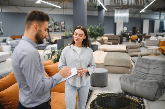 Sales consultant assisting female buyer in furniture store