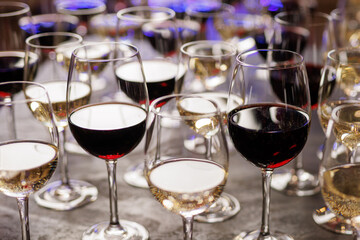 Red and white wine glasses arranged in rows on event table