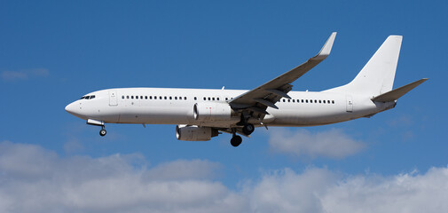 Obraz premium The plane lands. Airplane, passengers flying in the blue sky, preparing to land at the airport 