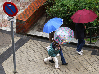 personas con paraguas de colores bajo la lluvia