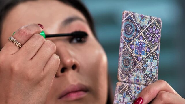 Woman Applying Eyeliner, Brow Gel, and Mascara Makeup