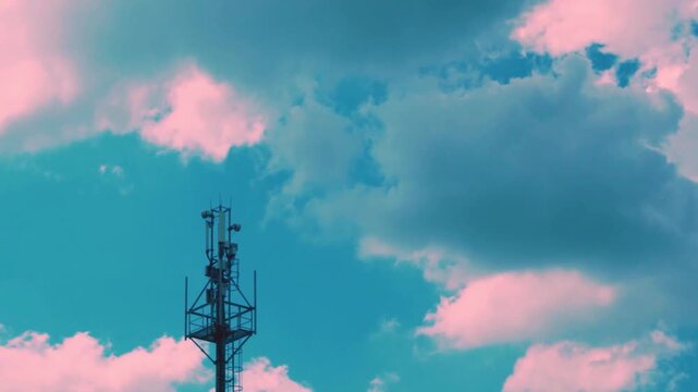 Cell Tower, Cellular GSM tower with 3g, 5g Transmitter, Antenna, Tower, Mobile Communication Equipment of Mobile Operator and Time Lapse of Sunset Blue Azure Sky Pink Gray Fluffy Clouds in Sunlight.