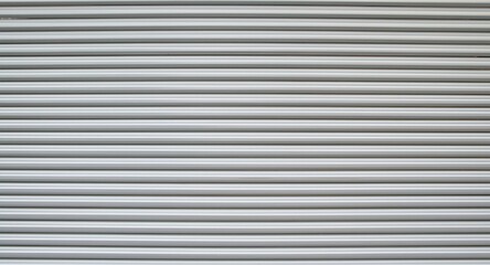 Fototapeta premium Evenly spaced horizontal lines on silver grey corrugated metal panel with smooth surface background