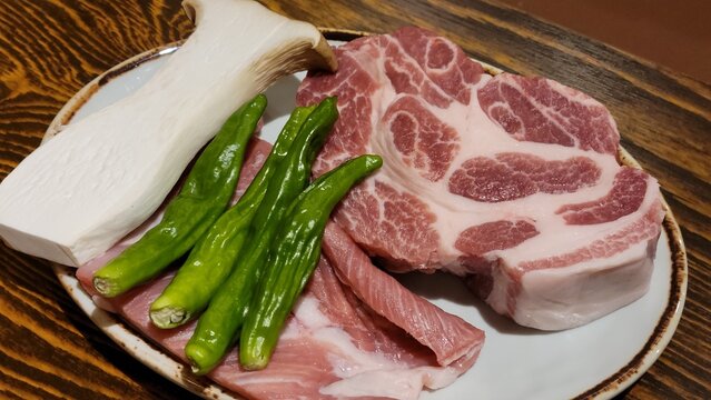 Uncooked Pork Shoulder Meat and Vegetables Ready to Cook on a Plate