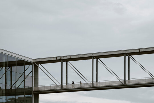 Steel skywalk walkway bridge in Berlin Germany with modern architecture forming an urban connection under a cloudy sky above the city