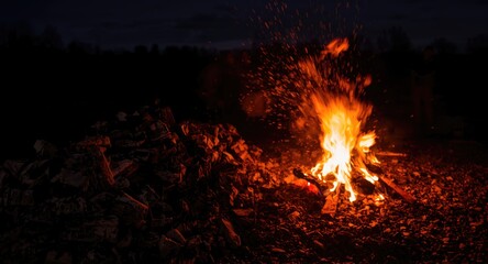 charcoal stacked near an intense fire in a nighttime scene