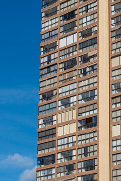 Residential architecture of apartment building tower with windows and facade lines against sky in Benidorm Spain showing modern urban density