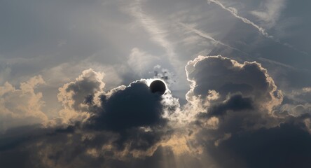 Fototapeta premium Dramatic cloudscape surrounding a tranquil eclipse in a majestic sky