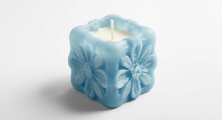 Detailed artistic photo of a blue floral soy wax candle in bubble cube shape handmade on white background