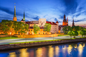 Naklejka premium Riga, Latvia. Twilight scene of historical European town along Daugava riverfront