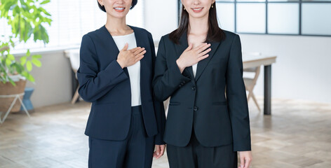 胸に手を当てる女性