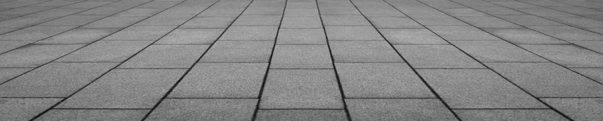 Abstract grey gray monochrome slabs stone floor pattern with geometric tile arrangement and perspective view creating a modern architectural surface in perspective view.