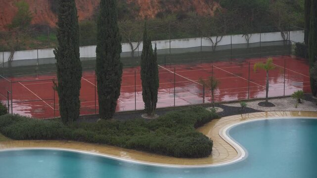 Wet Surface of Clay Tennis Court with Large Rain Water Puddle 