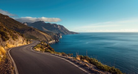 Fototapeta premium Asphalt road along scenic mountain coastline with blue sea and copy space