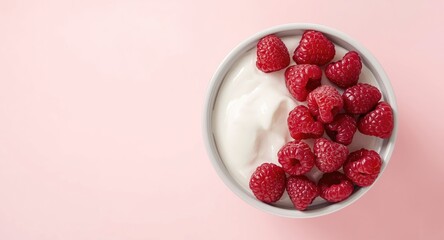 Elevated angle of thick Greek yogurt decorated with fresh raspberries together with clear copy space
