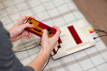 Girl playing a vintage game console. Retro style, nostalgia for the 80s and 90s. Millennial leisure.