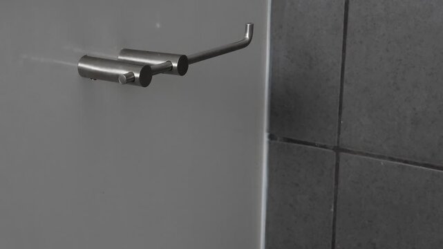 Stop motion of toilet paper unrolling on a holder until the roll is empty, bathroom interior, minimal concept of shortage, consumption, waste and daily hygiene