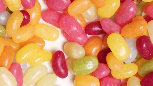 Colorful small jelly candies moving randomly in stop motion. . Seamless loop. Playful and vibrant background for candy, desserts, kids products, food advertising, and festive mood