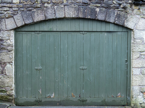 Historic Distressed Green Wooden Door in Limestone Stone Wall