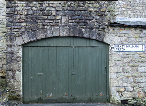 Historic Green Wooden Workshop Door in Limestone Stone Wall