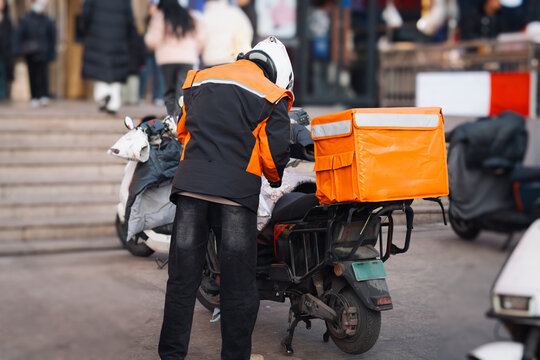 Delivery Worker with Orange Bag on Scooter