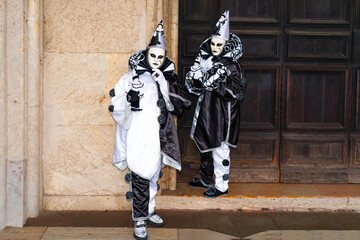 Venetian carnival performers in dramatic black and white masks and costumes. Concept of theatre, tradition and artistic expression
