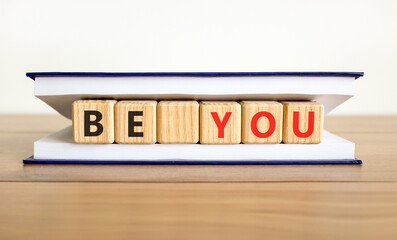 Be you support and help symbol. Concept word Be you on beautiful wooden blocks in beautiful book. Beautiful wooden table white background. Business be you support and help concept. Copy space.