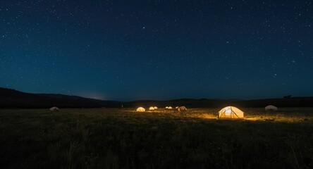 Brilliant stars casting light on tents in a vast grassy landscape