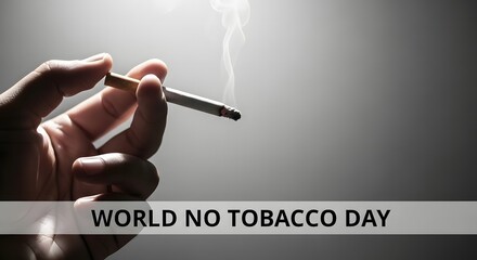 Close-up of hand holding lit cigarette with smoke rising, World No Tobacco Day concept