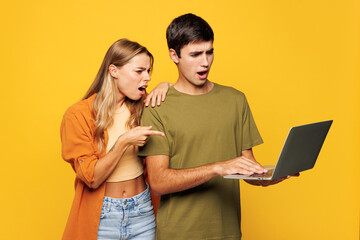 Young sad couple two friends family IT man woman wears casual clothes hold use work point finger on...